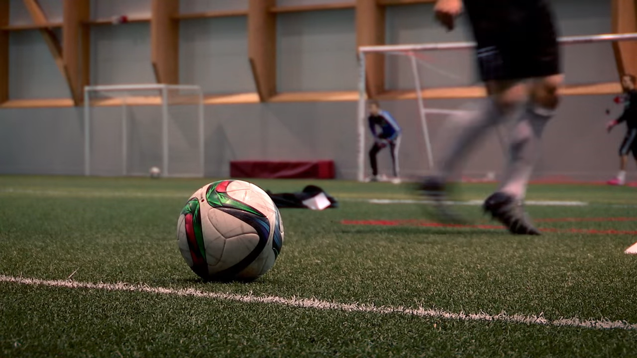 Kids practicing soccer indoors