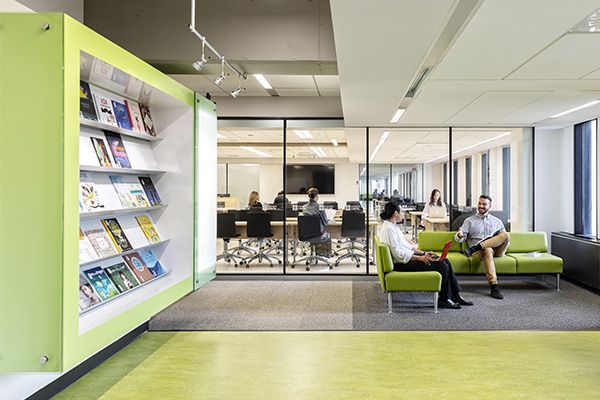 Bibliothèque avec 2 personnes assises sur divan