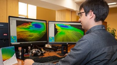 étudiant devant des écrans d'ordinateur